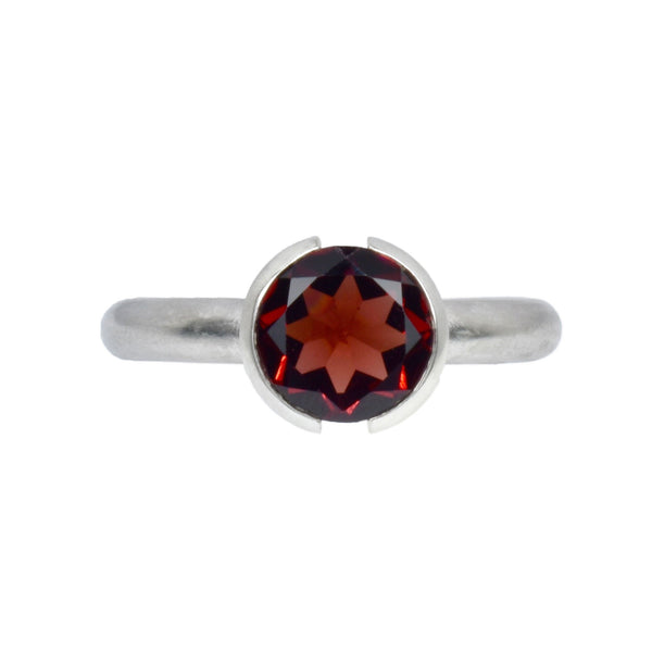 The open bezel ring with a red garnet gemstone