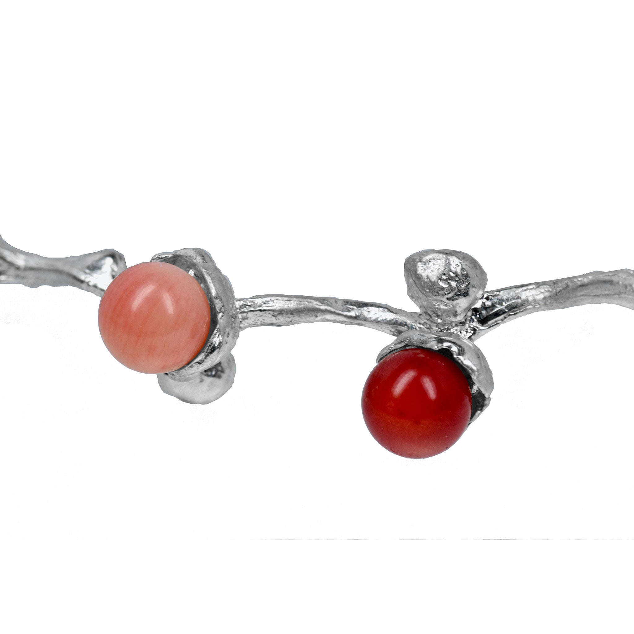 le bracelet en perles de corail argenté sur une branche de dattes
