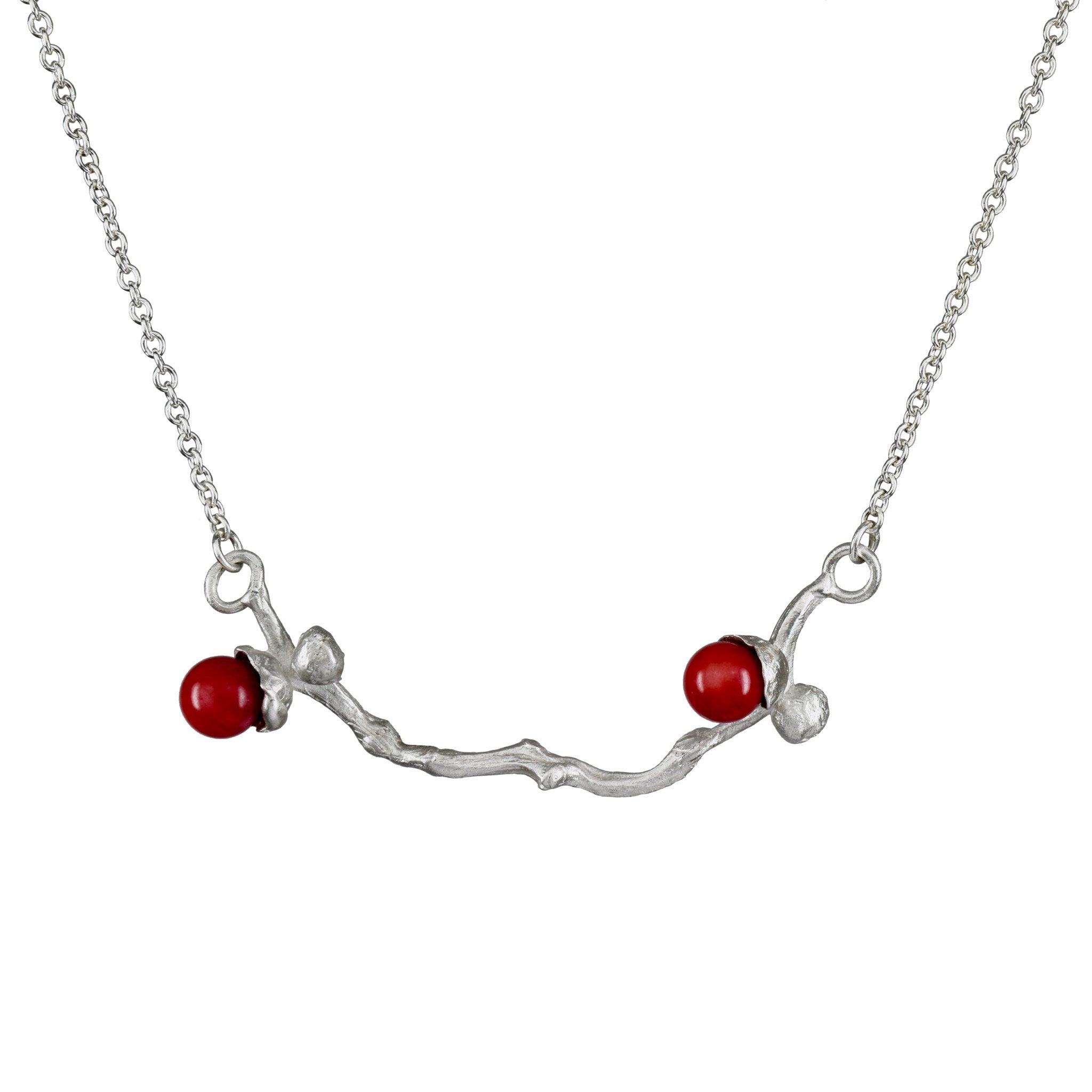 le collier de perles de corail argenté sur une branche de dattes