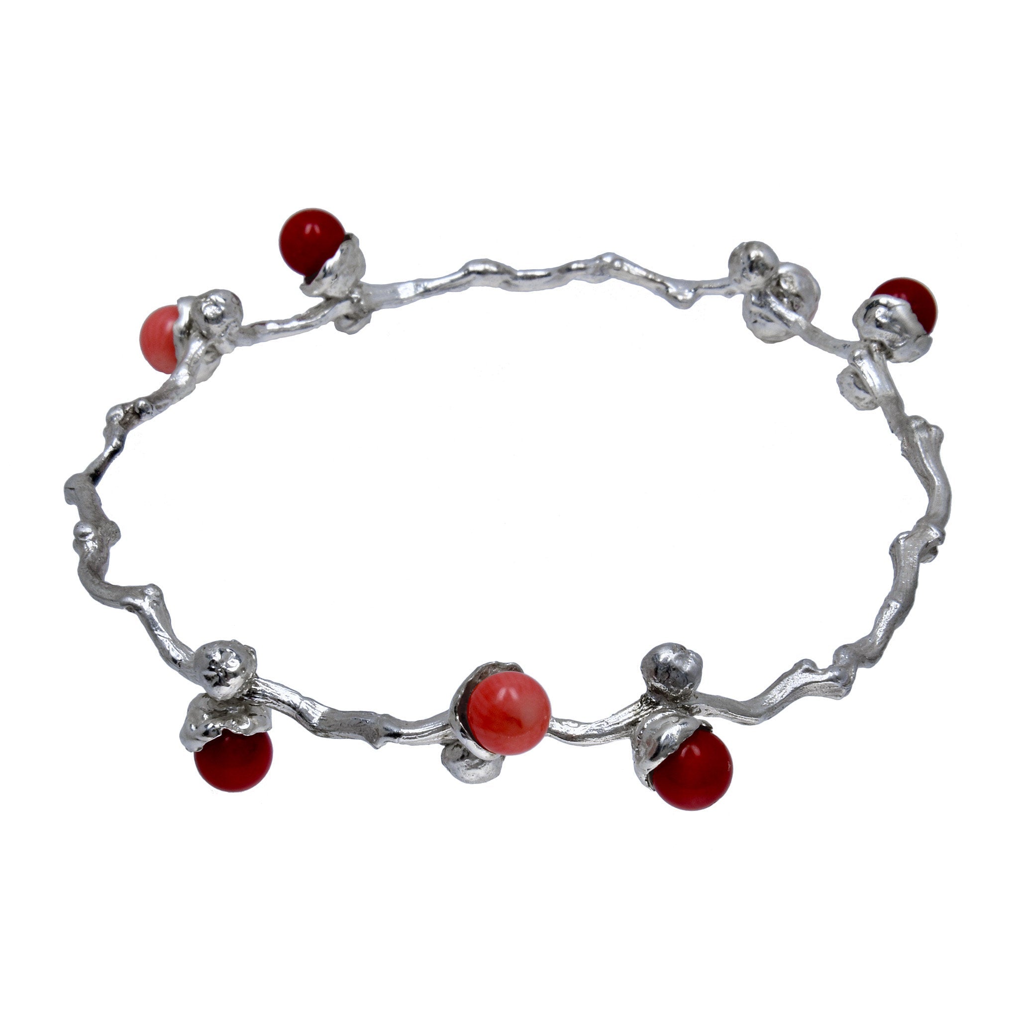 le bracelet en perles de corail argenté sur une branche de dattes