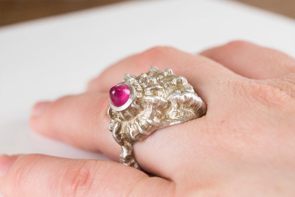La bague coquillage moulée à partir d'un coquillage avec une pierre précieuse taillée en balle