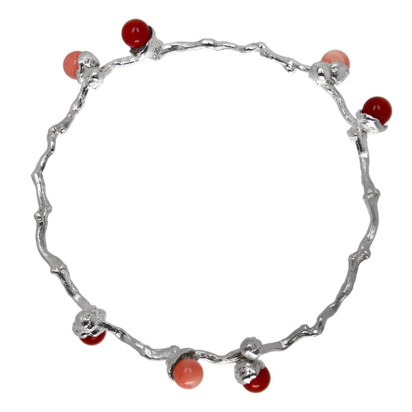 le bracelet en perles de corail argenté sur une branche de dattes