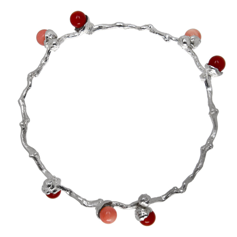le bracelet en perles de corail argenté sur une branche de dattes